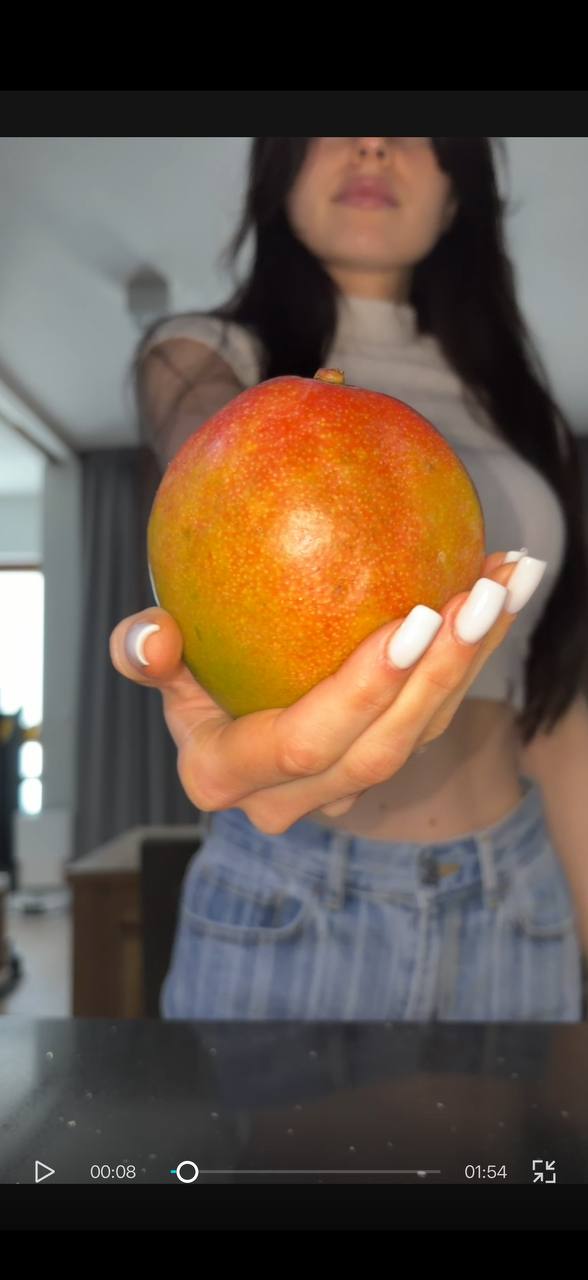 Sofia holding fresh mango for mango sticky oats recipe