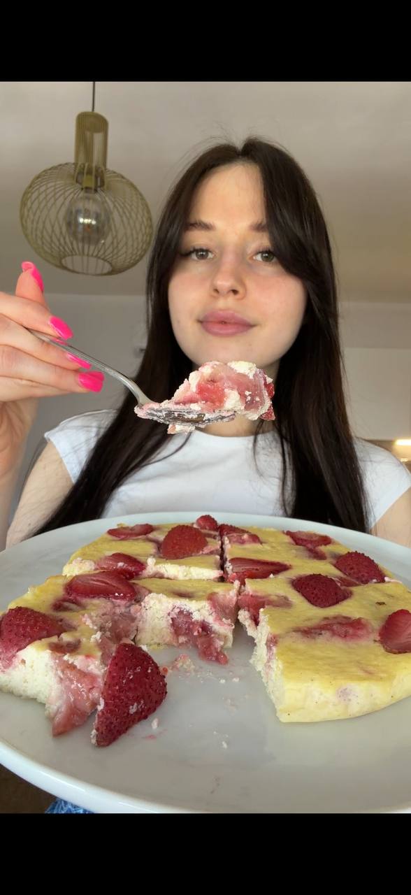 Sofia serving a slice of strawberry cheesecake bake with fresh strawberries on the side