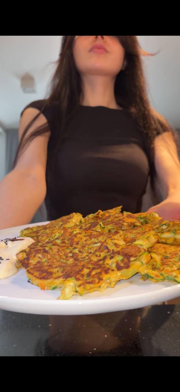 Sofia serving golden zucchini fritters on a white plate